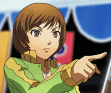 a girl in a green and yellow jacket points her finger