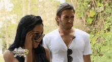a man and a woman are standing next to each other and the man is wearing a white shirt .