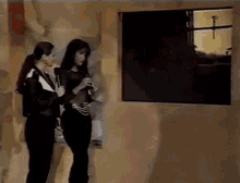 a couple of women standing next to each other with a microphone