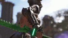 a video game character is holding a green sword with a light on it .