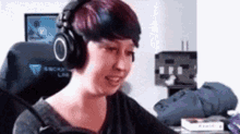 a woman wearing headphones is sitting in a chair in front of a computer screen .