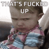 a baby is sitting in a car seat with the words `` that 's fucked up '' written on his face .