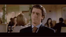 a man in a suit and tie is making a face .
