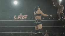 two women wrestling in a ring with a sign that says lfg