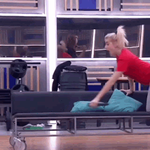 a woman in a red shirt sits on a black couch