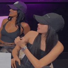 two women wearing hats one of which says " let 's " on the front