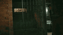 a man in a black jacket is standing in a dark room next to a window .