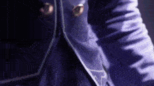 a close up of a person wearing a blue jacket with gold buttons .