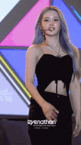 a woman with blue hair is standing in front of a colorful background with the words izyenathan on the bottom