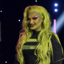 a woman with long green hair and pink makeup
