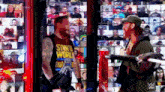 a man wearing a tank top that says storm the world stands next to another man