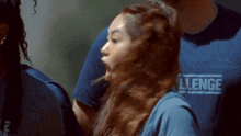 a woman is wearing a blue shirt that says challenge on it