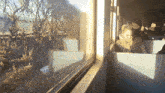 a man sits on a train looking out the window with a sign that says 103