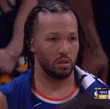 a man with dreadlocks and a beard is wearing a basketball jersey that says nyk on it