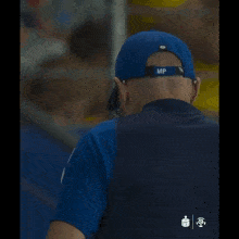 a man in a blue adidas shirt sits on a white box
