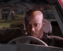 a man is sitting in the driver 's seat of a car .