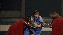 a group of people are dancing on a stage and one of them is wearing a blue coat
