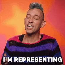 a man with a mohawk is wearing a striped sweater and says i 'm representing