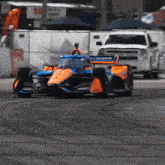 an orange and blue race car with the word castrol on the side