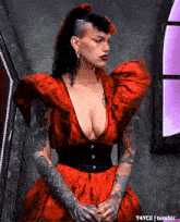a woman wearing a red dress with a plunging neckline