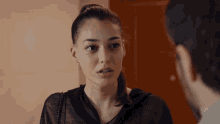 a woman is talking to a man in front of a wooden door