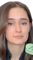 a close up of a woman 's face with a green heart that says " embrace " on it