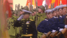 a group of soldiers marching in a line with a man in a black uniform