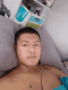 a man laying on a bed with a tattoo on his chest that says " pk "