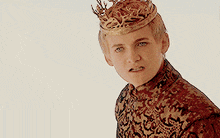 a young man wearing a crown is making a funny face