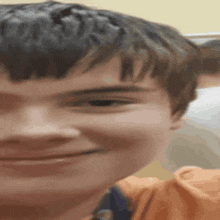 a close up of a young boy 's face with a slight smile on his face