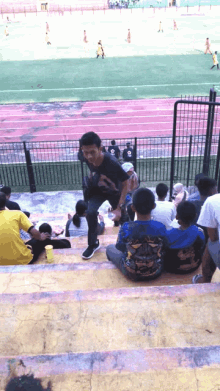 a group of people sitting on stairs in a stadium watching a soccer match