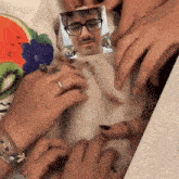 a group of people are holding a picture of a man with glasses and a mustache