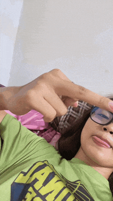 a girl wearing glasses and a green shirt that says jamaica on it