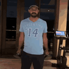 a man with a beard wearing a light blue argentina 14 shirt