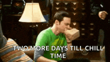 a man in a green shirt is sitting on a couch with a box in his mouth and the words `` two more days till chill time ''