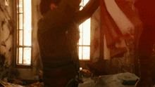 a person is standing in a dark room holding a red flag