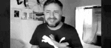 a black and white photo of a man with a beard wearing a black puma shirt .