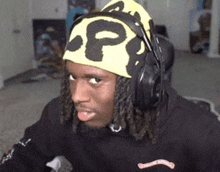 a man wearing headphones and a headband that says pp