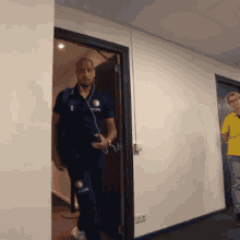 a man wearing headphones walking through a doorway