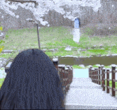 a woman with long black hair is looking down a set of stairs