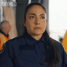 a woman in a blue uniform with the word skymed written on the bottom