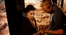 a man is putting a wedding ring on a woman 's finger