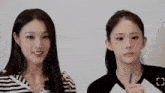 two young women are standing next to each other and smiling .