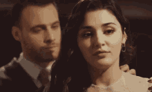 a man and a woman are standing next to each other .