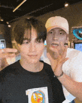 a man wearing a hat that says tokyo on it stands next to another man