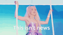 a woman in a purple dress is hanging on a rope with the words `` this isn 't news '' written below her