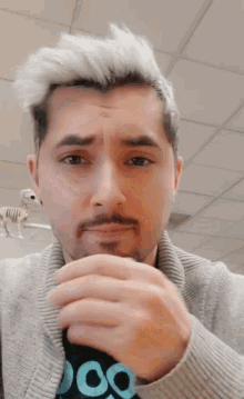a man with white hair and a beard is wearing a sweater with the word doo on it