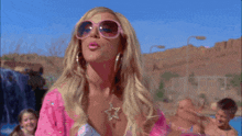 a woman wearing sunglasses and a pink shirt says " read my lips "