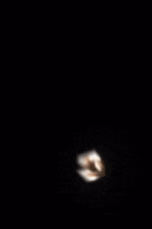 a person 's shadow is cast on a white box in a dark room .