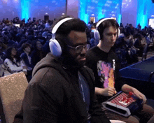 a man wearing headphones has a lanyard around his neck that says ' a ' on it